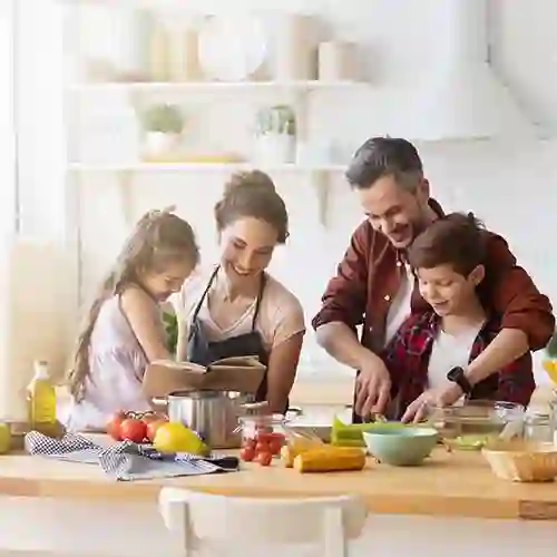 Family cooking in a kitchen with a rangehood above the cooktop